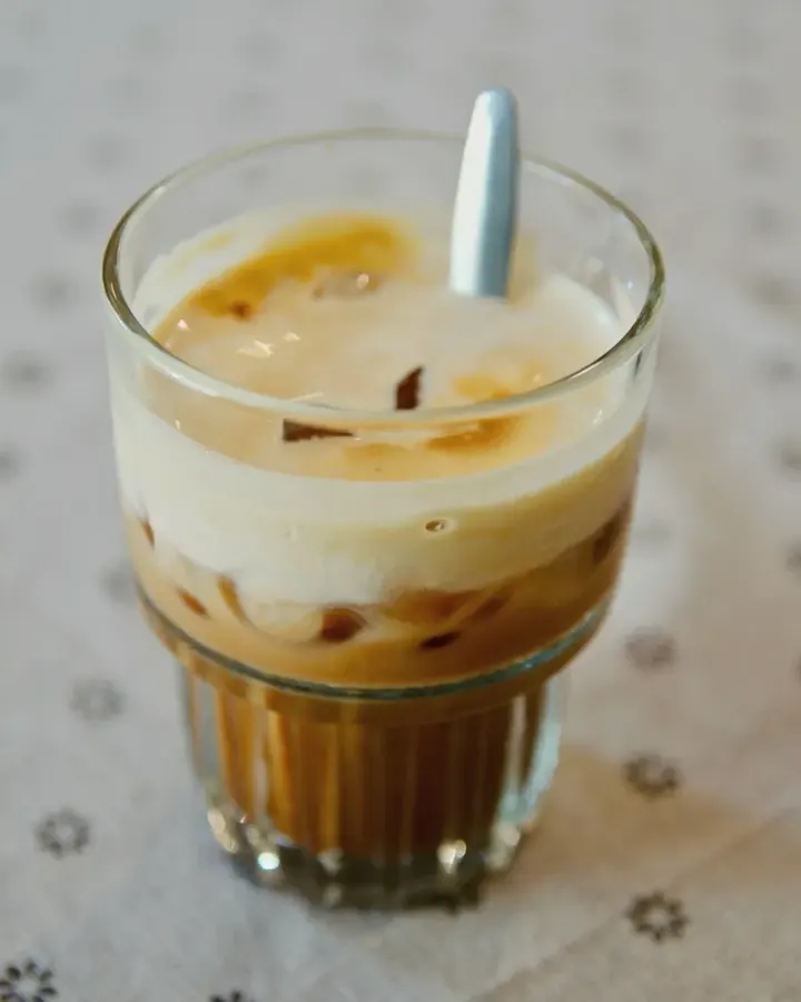 A glass of iced coffee on a café table