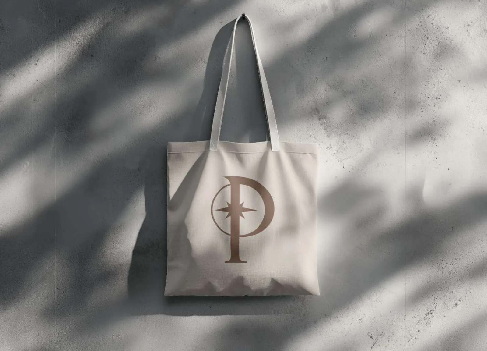 A tote bag with the compass mark in dappled light
